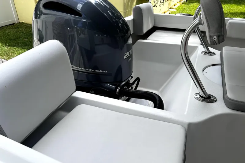 Slide: The Image of 2023 Parker 2120 Sport Cabin boat interior with outboard motor and seating. - 33
