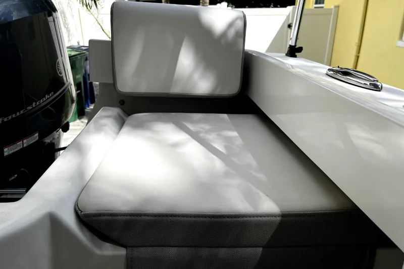 Slide: The Image of 2023 Parker 2120 Sport Cabin boat seat with cushioned backrest and outboard motor. - 34