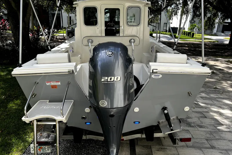 Slide: The Image of 2023 Parker 2120 Sport Cabin boat with Yamaha 200 engine, parked outdoors. - 5