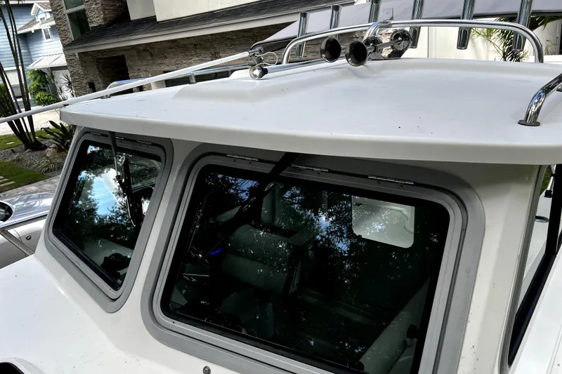 Slide: The Image of 2023 Parker 2120 Sport Cabin boat with sleek windows and roof railings. - 53