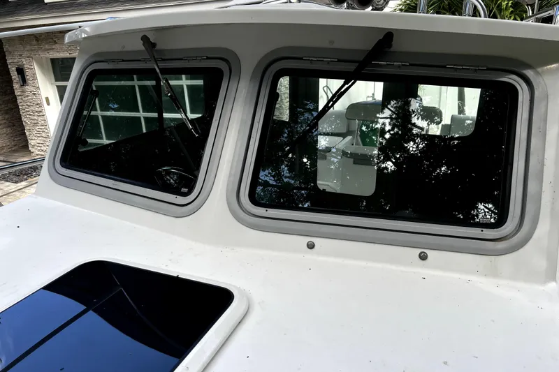 Slide: The Image of 2023 Parker 2120 Sport Cabin boat windows with wipers, exterior view. - 54