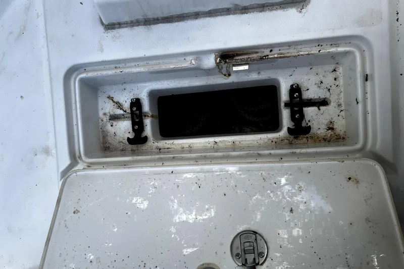 Slide: The Image of 2023 Parker 2120 Sport Cabin storage compartment with dirt and debris. - 56