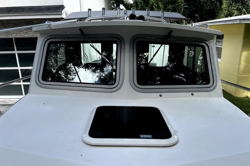 Slide: The Image of 2023 Parker 2120 Sport Cabin boat with dual front windows and roof hatch. - 59