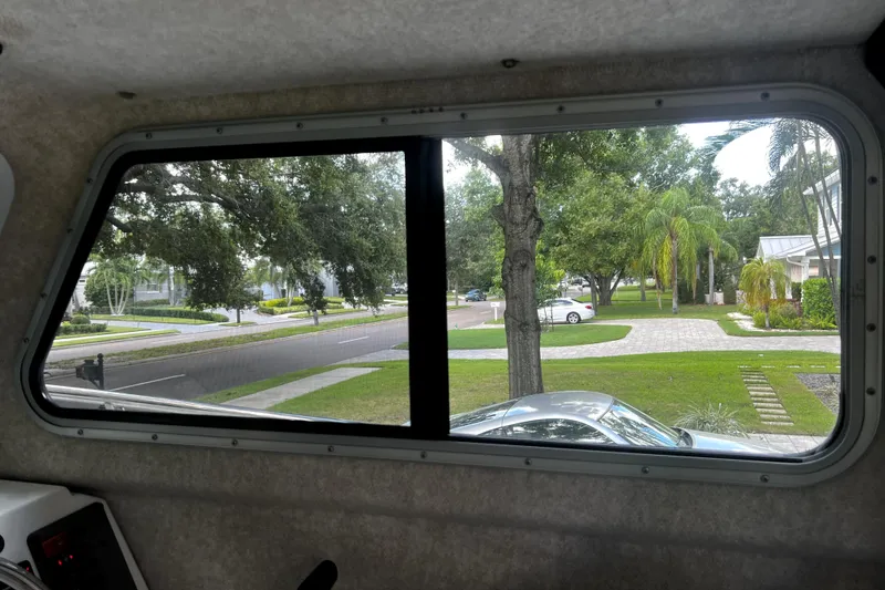 Slide: The Image of View from inside a 2023 Parker 2120 Sport Cabin, showing a suburban street and greenery. - 74