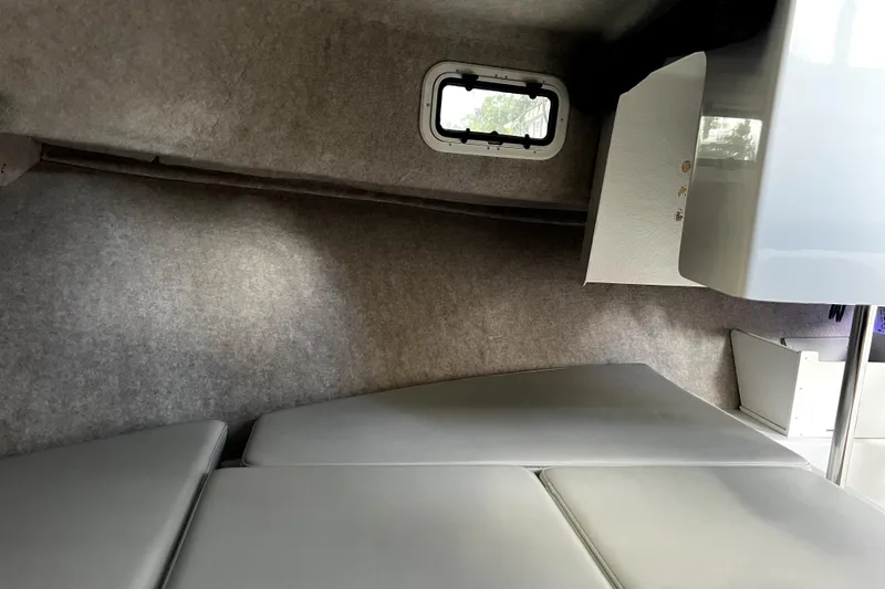 Slide: The Image of 2023 Parker 2120 Sport Cabin interior with cushioned seating and small window. - 85