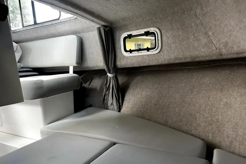 Slide: The Image of Interior of 2023 Parker 2120 Sport Cabin, featuring cushioned seating and a small window. - 89