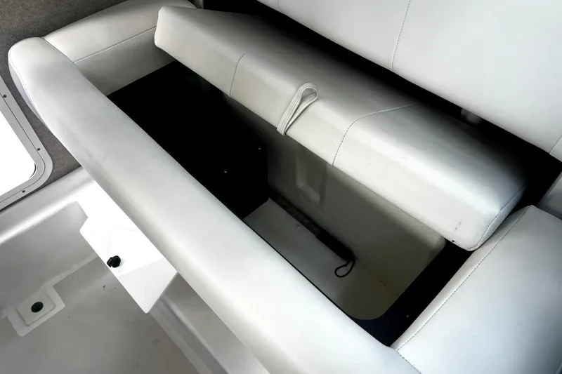Slide: The Image of 2023 Parker 2120 Sport Cabin boat interior storage compartment with cushioned seating. - 93