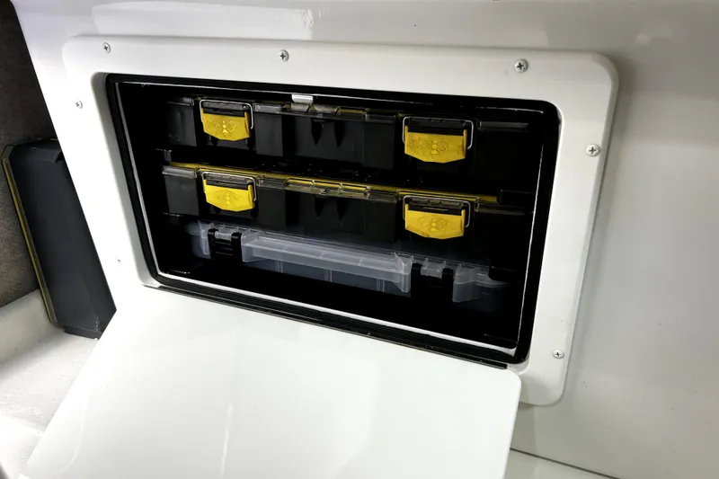 Slide: The Image of Storage compartment in 2023 Parker 2120 Sport Cabin boat with organized tackle boxes. - 95