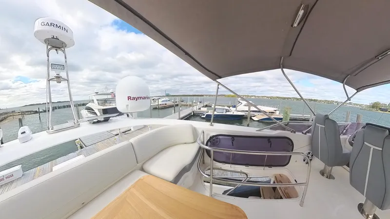 Slide: The Image of 2018 Princess S60 yacht deck with seating, docked at marina under cloudy sky. - 27