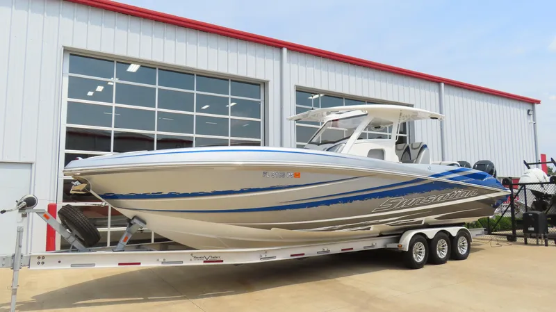Slide: The Image of 2015 Sunsation 34 CCX boat on trailer outside a modern building. - 1