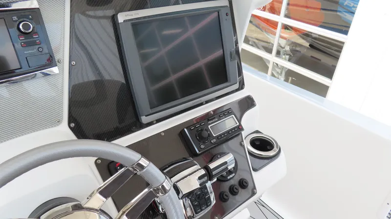 Slide: The Image of 2015 Sunsation 34 CCX boat dashboard with steering wheel and electronic controls. - 12