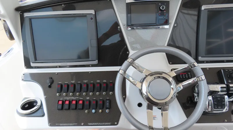 Slide: The Image of 2015 Sunsation 34 CCX boat dashboard with steering wheel and control panels. - 14