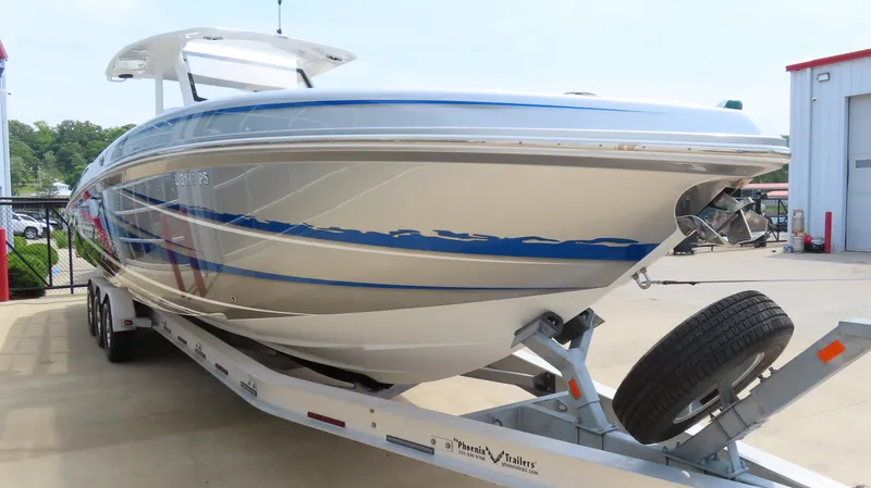 Slide: The Image of 2015 Sunsation 34 CCX boat on trailer, sleek design, parked outdoors. - 2