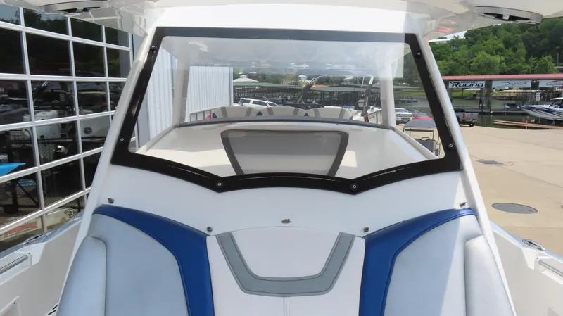Slide: The Image of 2015 Sunsation 34 CCX boat with blue and white seating, docked near a marina. - 25