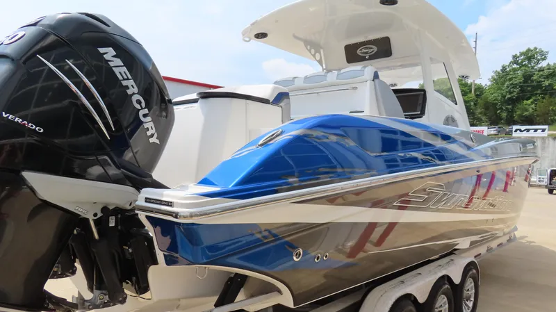 Slide: The Image of 2015 Sunsation 34 CCX boat with Mercury engine, blue and silver design, on trailer. - 3