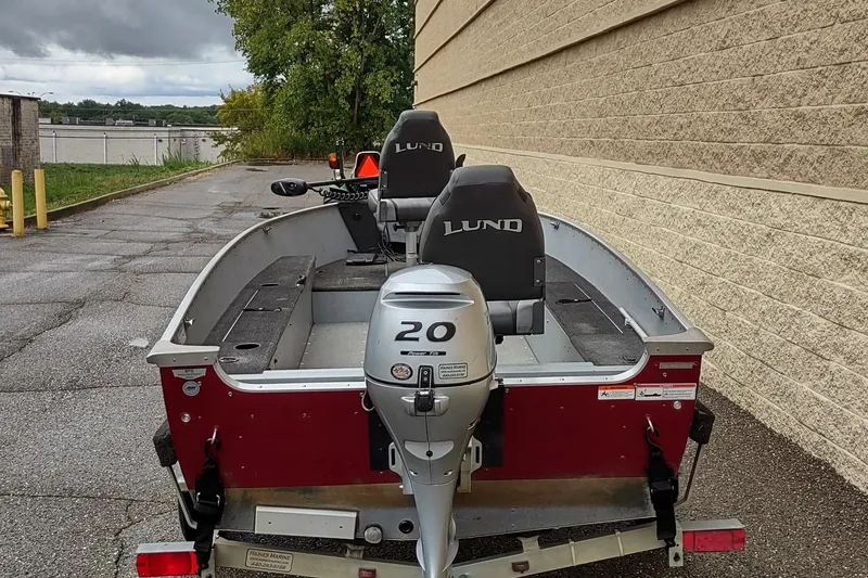 Slide: The Image of 2015 Lund 1600 Fury Tiller boat with 20 HP motor, parked outdoors. - 3