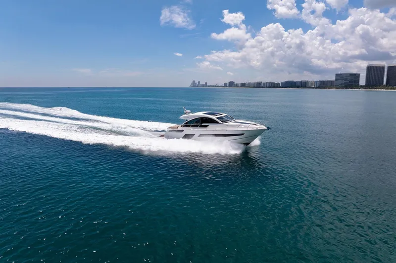 Slide: The Image of 2018 Fairline Targa 53 OPEN yacht cruising on clear blue ocean near city skyline. - 54