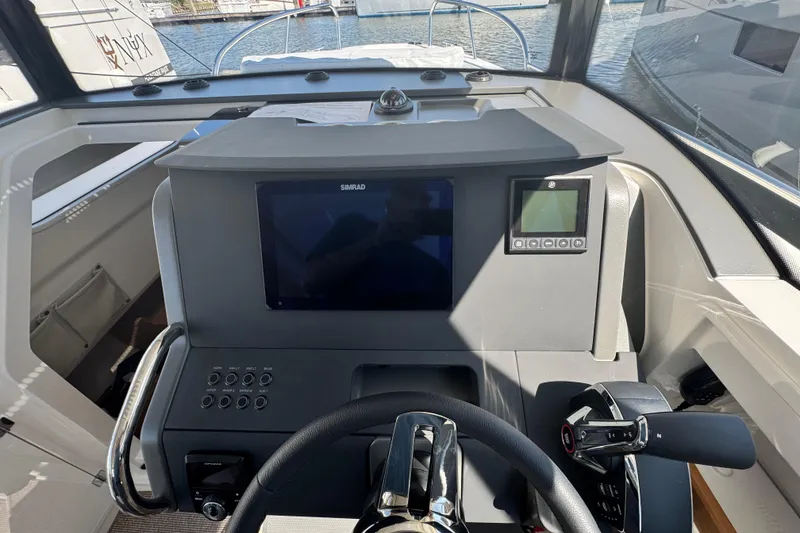 Slide: The Image of Helm of 2025 Nimbus Commuter 9 boat with modern navigation controls and steering wheel. - 12
