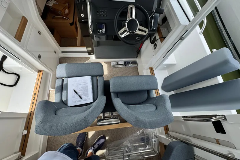 Slide: The Image of Interior of 2025 Nimbus Commuter 9 boat with modern seating and steering wheel. - 17