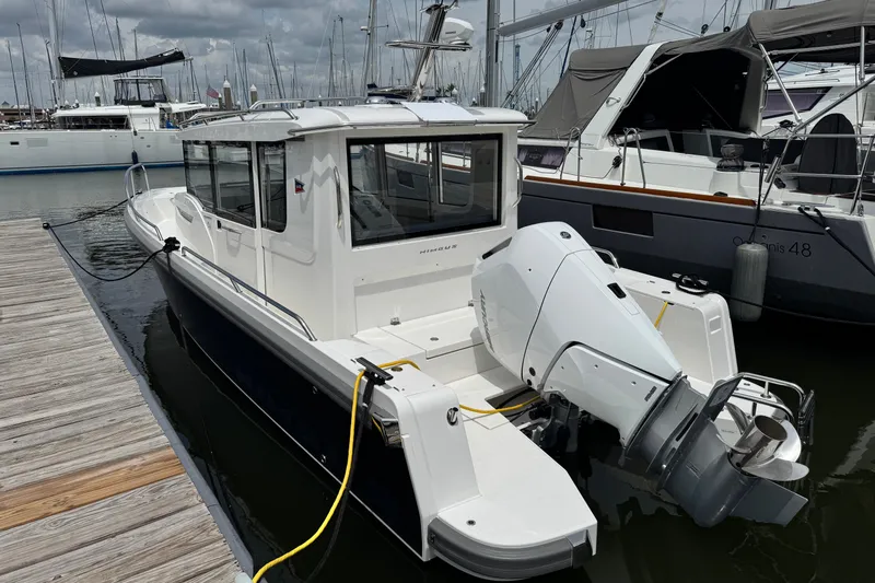 Slide: The Image of 2025 Nimbus Commuter 9 boat docked at marina, featuring sleek design and modern outboard motor. - 3