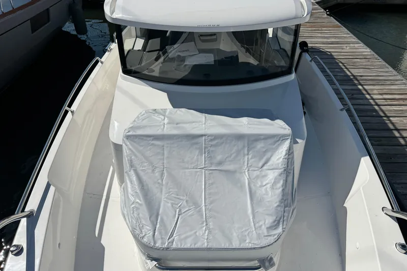 Slide: The Image of 2025 Nimbus Commuter 9 boat docked, featuring covered seating and sleek design. - 6