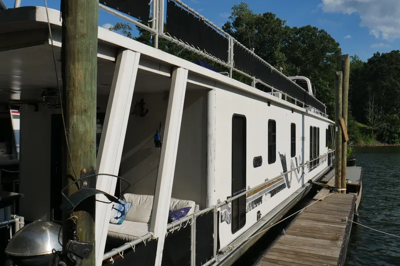 Slide: The Image of Houseboat interior with spiral staircase, anchor-themed decor, and lush riverside view. STARDUST Cruiser 1996. - 38