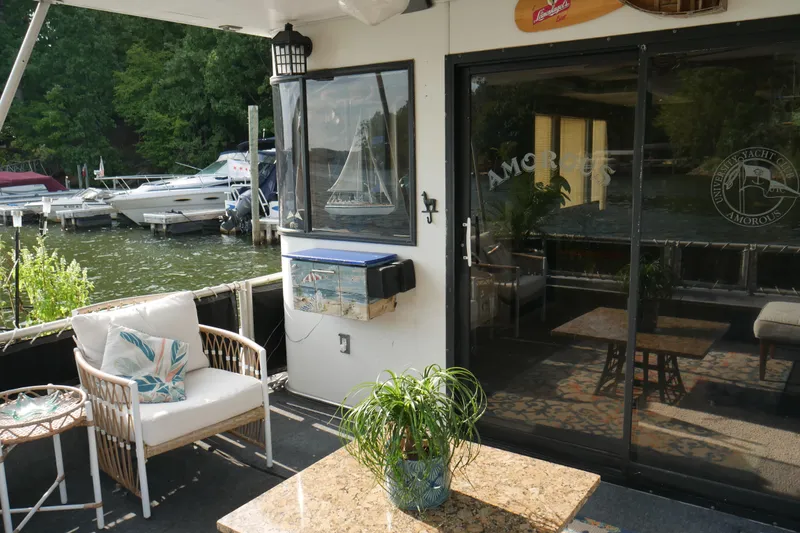 Slide: The Image of Luxurious 1996 STARDUST Cruiser houseboat with elegant outdoor seating and scenic lake view. - 4