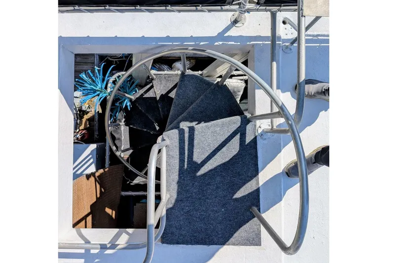 Slide: The Image of 1996 STARDUST Cruiser houseboat docked with outdoor seating and spiral staircase. - 40