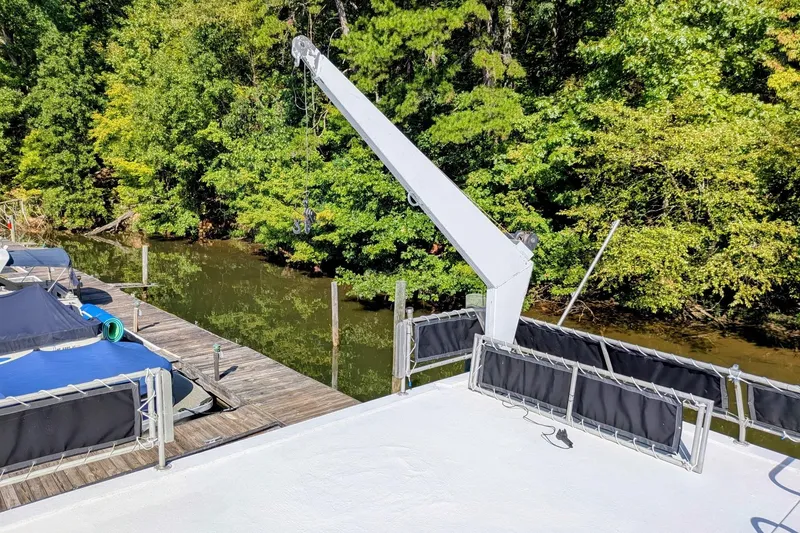 Slide: The Image of 1996 STARDUST Cruiser houseboat docked on a sunny day, surrounded by lush greenery. - 42