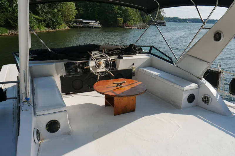 Slide: The Image of 1996 STARDUST Cruiser boat deck with chairs, table, and umbrella on a sunny day. - 48