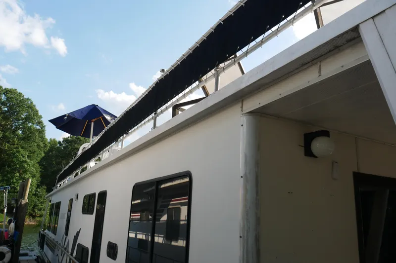 Slide: The Image of Deck of 1996 STARDUST Cruiser with seating, umbrella, and scenic lake view. - 51