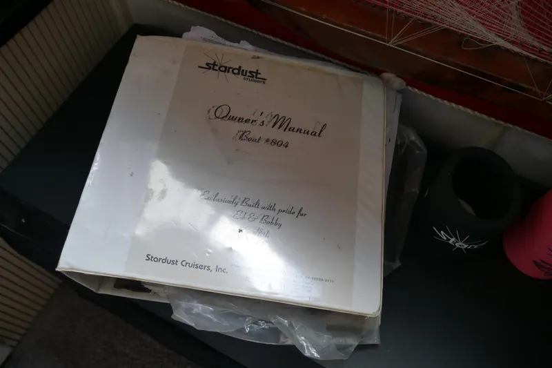 Slide: The Image of Owner's manual for 1996 Stardust Cruiser boat, model #804, on a table. - 60