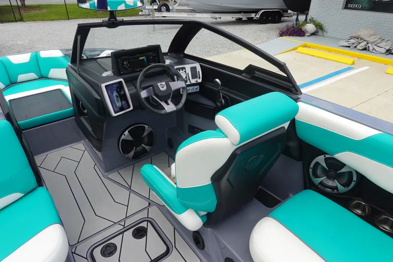 Slide: The Image of 2021 Malibu Wakesetter 22 LSV interior with teal and white seating, modern dashboard, and steering wheel. - 11