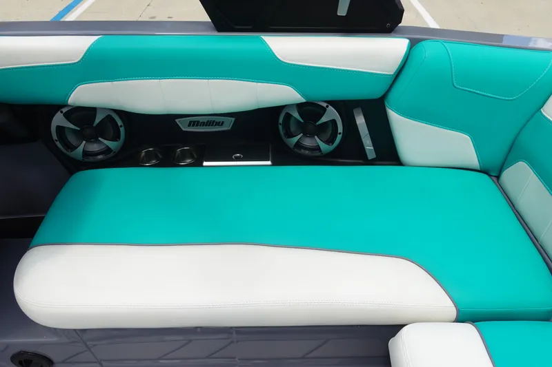 Slide: The Image of 2021 Malibu Wakesetter 22 LSV interior with teal and white seating, featuring speakers and cup holders. - 18