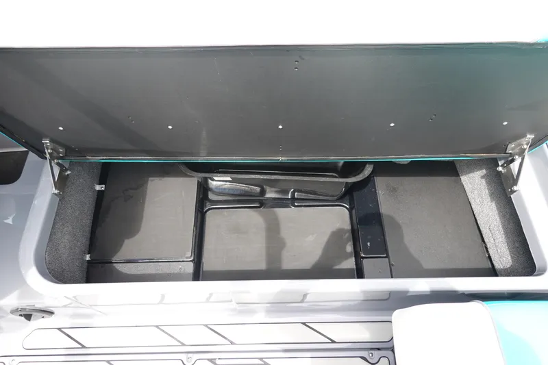 Slide: The Image of 2021 Malibu Wakesetter 22 LSV storage compartment, open and empty, with black interior. - 19