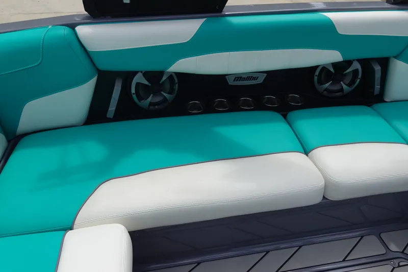 Slide: The Image of 2021 Malibu Wakesetter 22 LSV interior with teal and white seating, featuring speakers and cup holders. - 20