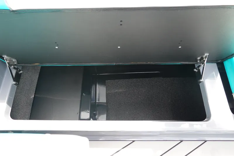 Slide: The Image of 2021 Malibu Wakesetter 22 LSV storage compartment, open and empty, with black interior. - 22