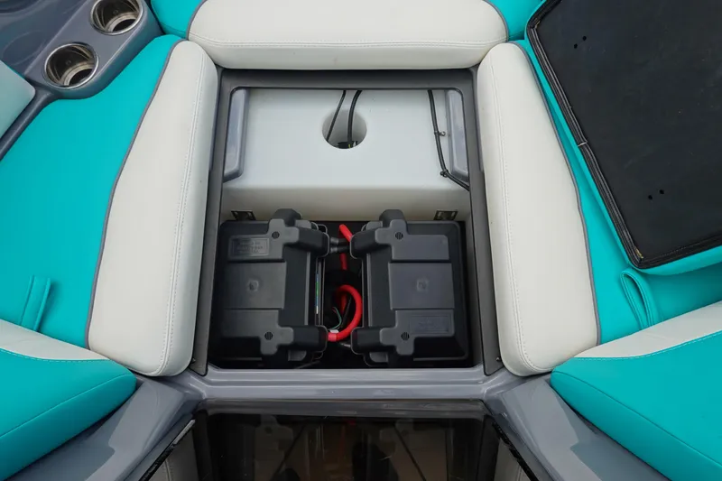 Slide: The Image of 2021 Malibu Wakesetter 22 LSV battery compartment with teal and white seating. - 34
