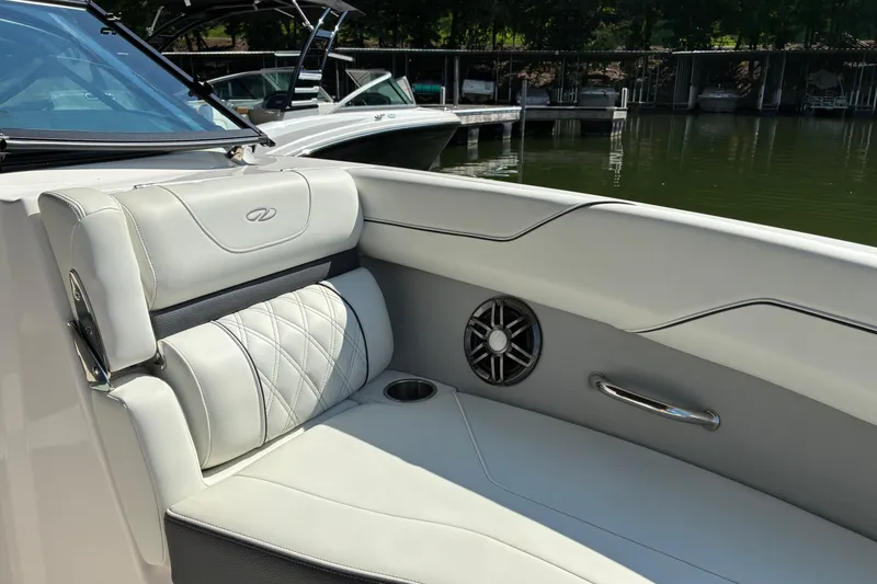 Slide: The Image of 2025 Regal LS2 boat interior with luxurious seating and speaker, docked by the water. - 22