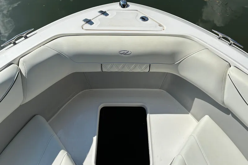 Slide: The Image of 2025 Regal LS2 boat interior with white cushioned seating and storage compartment. - 25