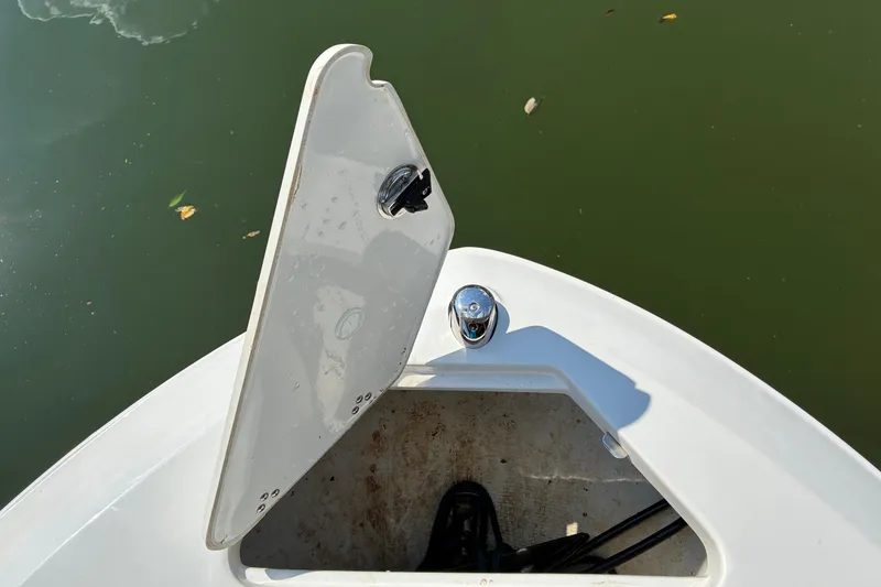 Slide: The Image of Open hatch on 2025 Regal LS2 boat, showing storage compartment by the water. - 26