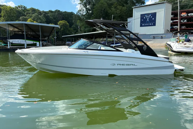 Slide: The Image of 2025 Regal LS2 boat docked at marina, surrounded by lush greenery and calm waters. - 3