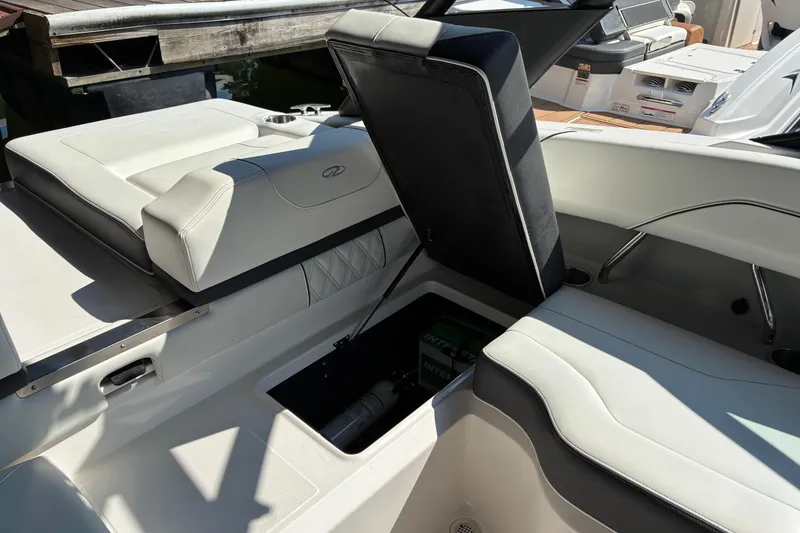 Slide: The Image of 2025 Regal LS2 boat interior with open storage compartment, showcasing sleek white seating. - 30