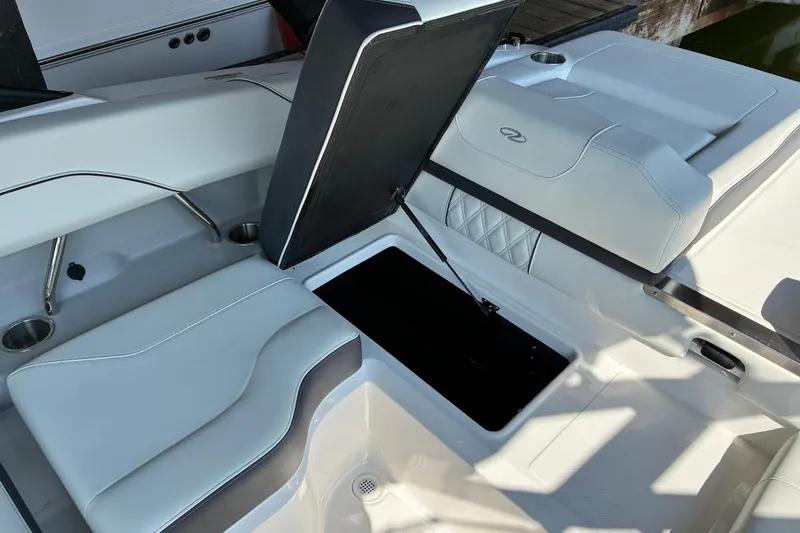 Slide: The Image of 2025 Regal LS2 boat interior with open storage compartment and cushioned seating. - 34