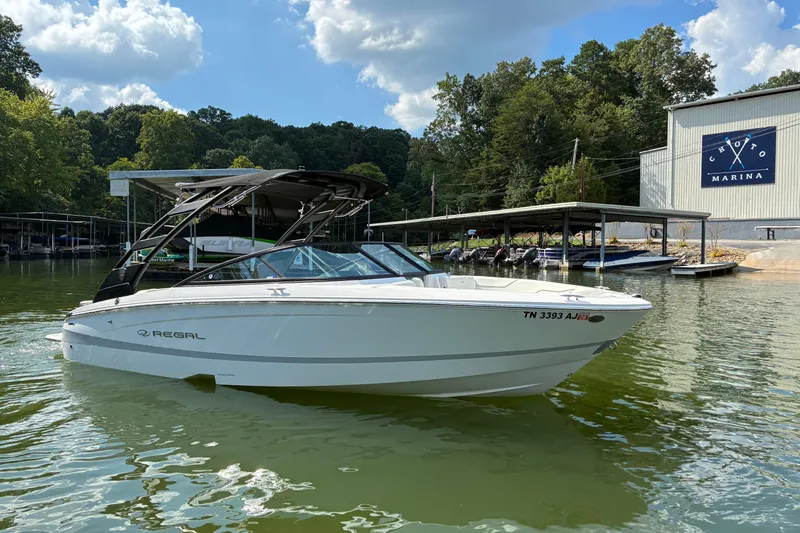 Slide: The Image of 2025 Regal LS2 boat docked at Choto Marina under a sunny sky. - 6