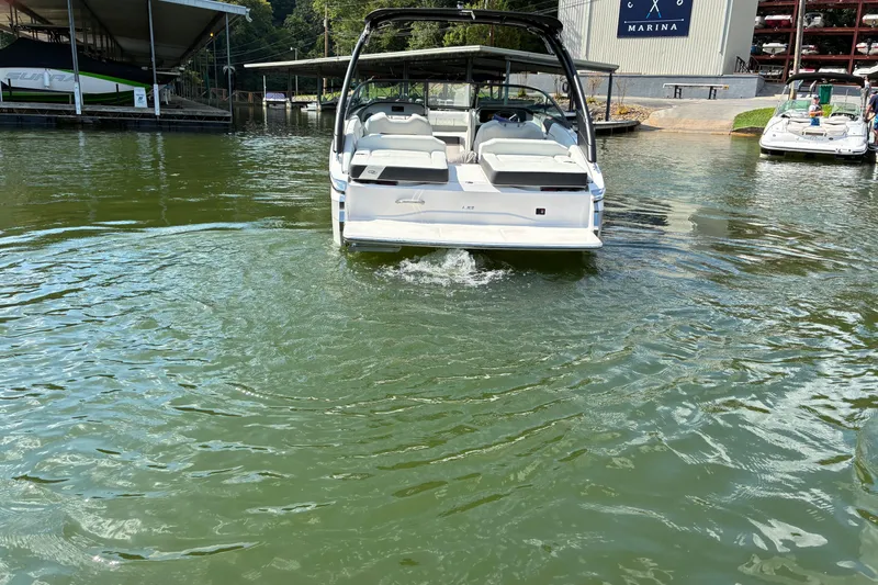 Slide: The Image of 2025 Regal LS2 boat docked at marina, rear view on calm water. - 9