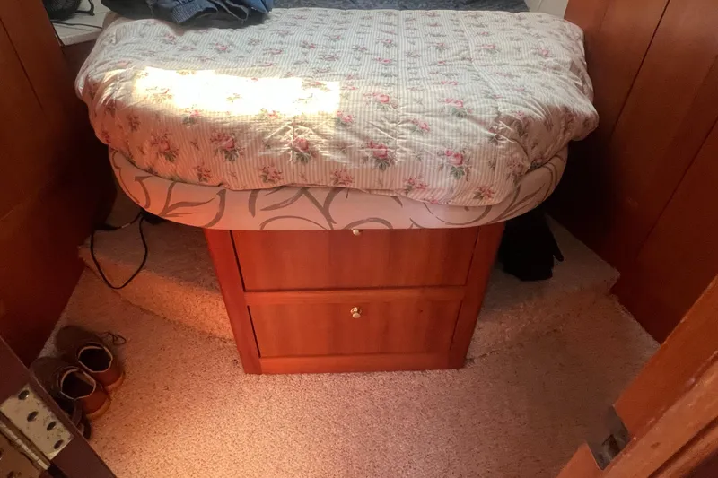 Slide: The Image of Cozy cabin bedroom in 2001 Mainship 390 Trawler with floral bedding and wooden storage. - 13