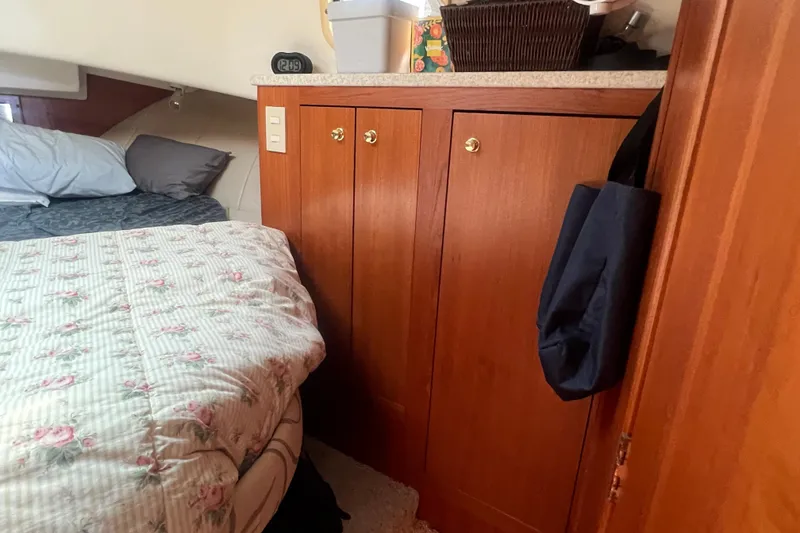 Slide: The Image of Cozy cabin interior of 2001 Mainship 390 Trawler with floral bedding and wooden cabinetry. - 14