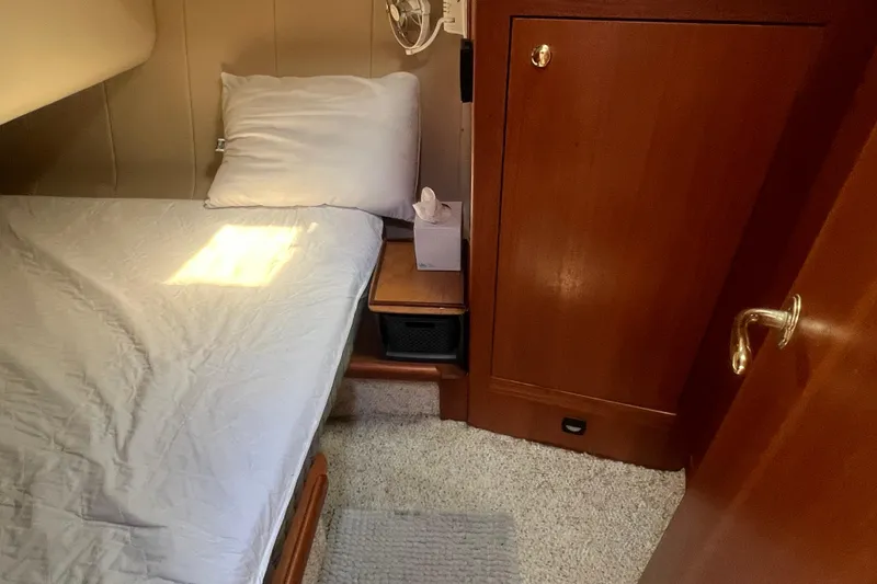 Slide: The Image of Cozy cabin interior of 2001 Mainship 390 Trawler with bed and wooden cabinetry. - 15
