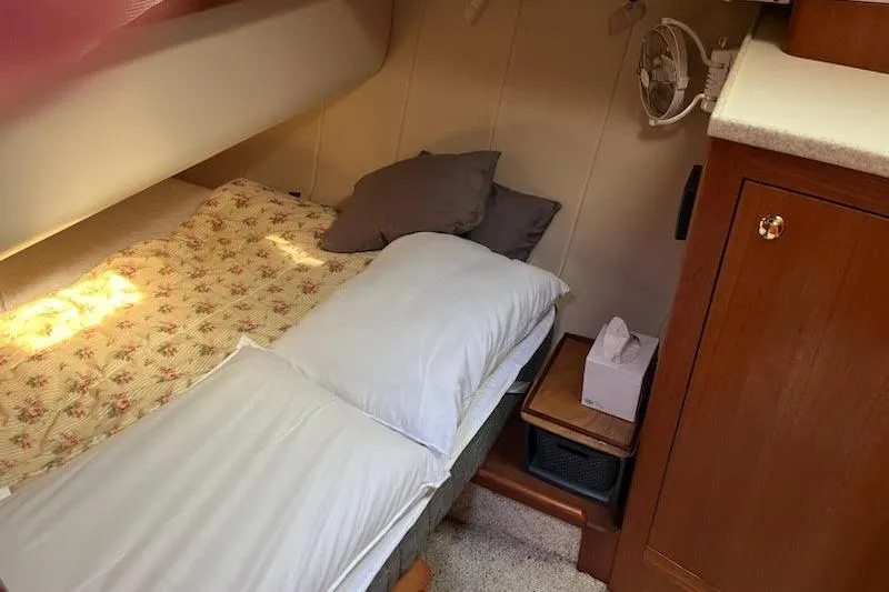 Slide: The Image of Cozy cabin interior of 2001 Mainship 390 Trawler with bed and wooden cabinetry. - 16